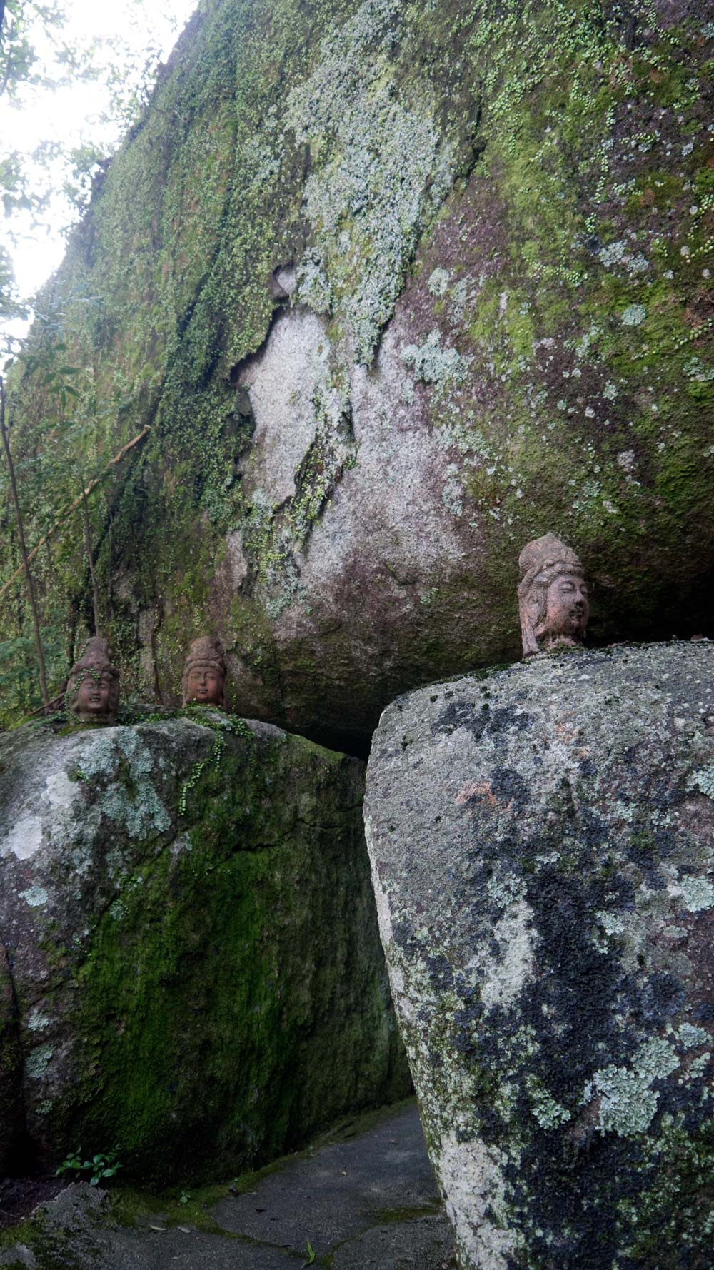 kannon statue heads on boulders