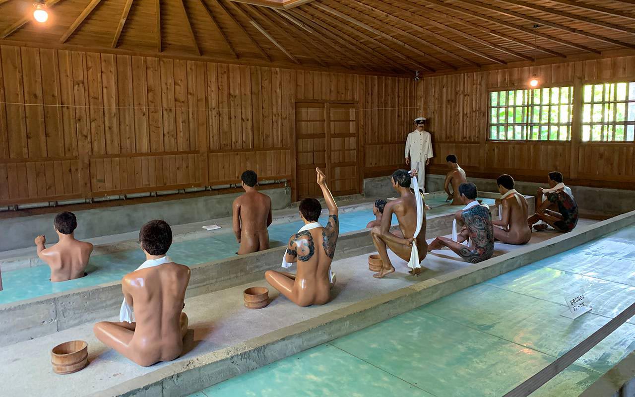 Lifesize models of prisoners washing and bathing in the prison bathhouse