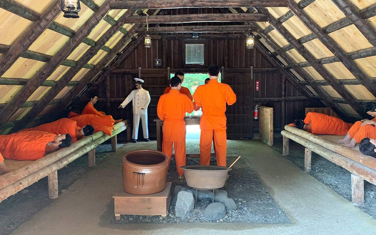 Lifesize models of prisoners and a guard inside temporary prison quarters